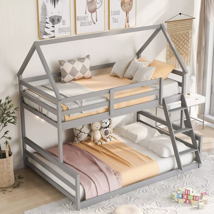 The bunk bed, complete with orange and red sheets, shown in a child’s bedroom.