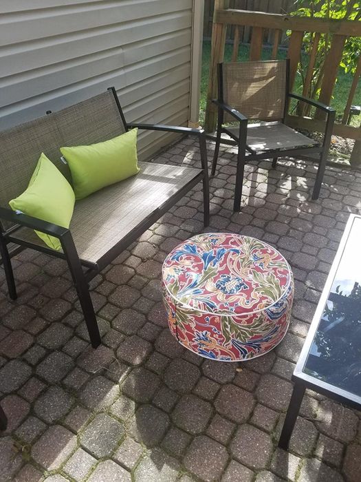 A reviewer photo showing a patio chair with a printed ottoman placed in front of it.