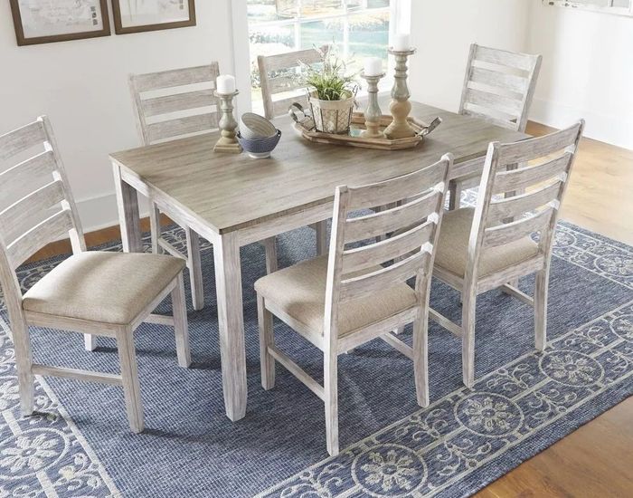 The stylish wooden dining set placed on a blue area rug, adding a touch of charm to the space.