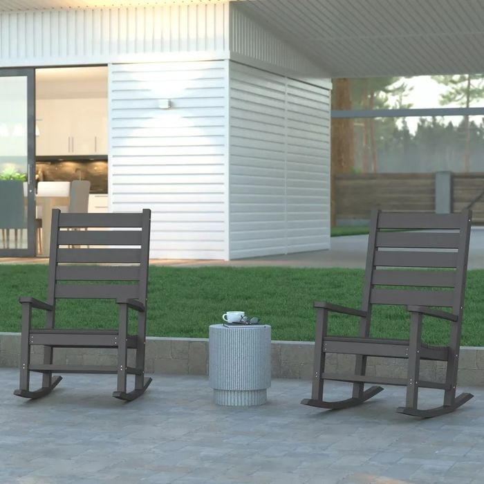 The grey rocking chairs set up on a beautiful outdoor patio.