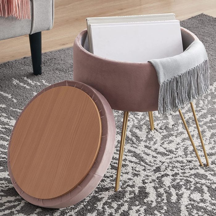 A blush pink velvet ottoman with gold hairpin legs and a removable lid