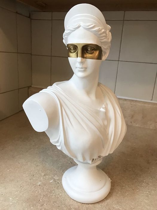 The reviewer's white bust is displayed on a countertop.