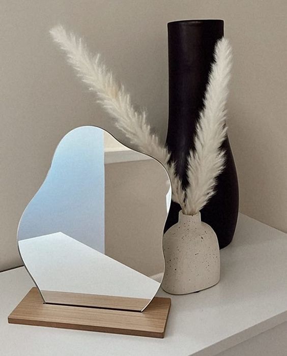 A reviewer's mirror displayed on a dresser, adding a sleek touch to the decor.