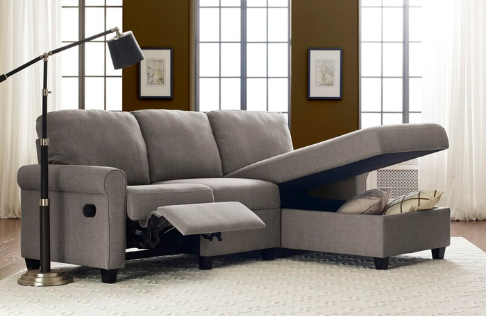 A lifestyle image of a gray sectional couch with built-in storage and reclining footrests, exuding both functionality and comfort.