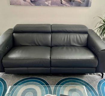 A reviewer’s photo showcasing a black leather sofa.