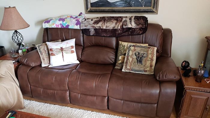 A reviewer’s photo of a brown leather three-seater sofa.