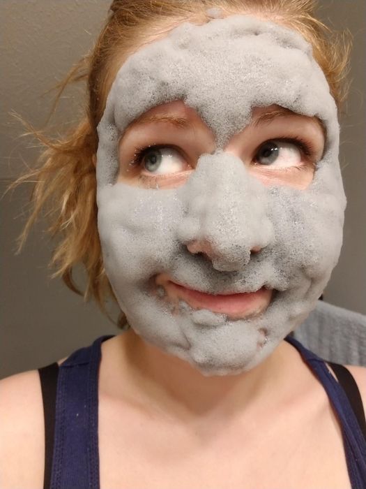 A reviewer wearing a bubbly face mask.