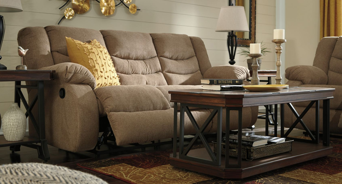 A beige reclining sofa with the footrest raised for optimal relaxation.