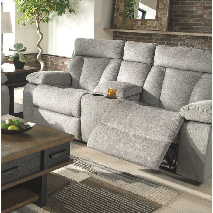 A lifestyle shot of a gray reclining couch with the footrest elevated, showcasing its comfort and style.