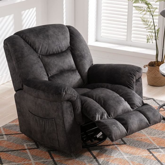 A plush reclining chair with an extended footrest, positioned on a patterned rug in a brightly lit living area