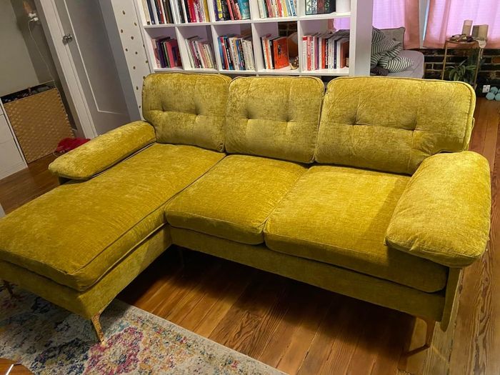 The reviewer's yellow sectional set in a cozy living room environment.