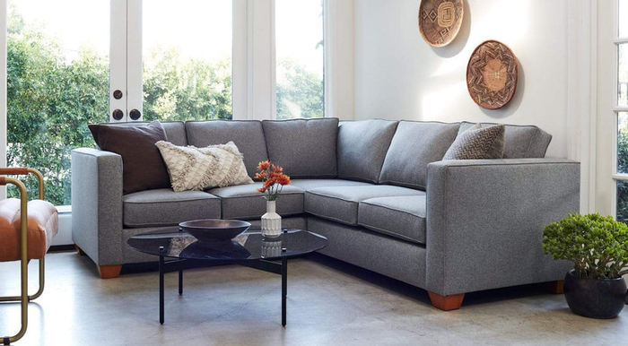 A lifestyle image of a sleek gray L-shaped couch in a cozy living space.
