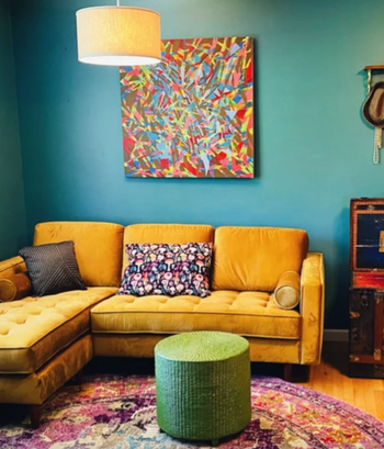 A photo from a reviewer capturing the couch in yellow, placed in the cozy corner of a living room.