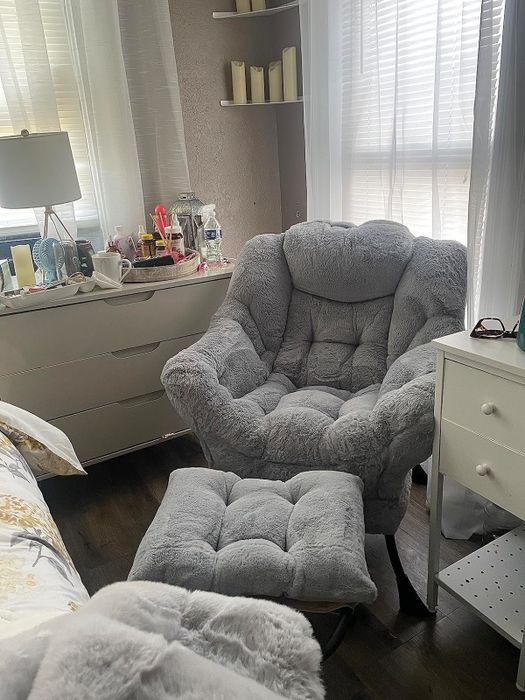 A soft gray armchair with a matching ottoman, placed in a warm and inviting room