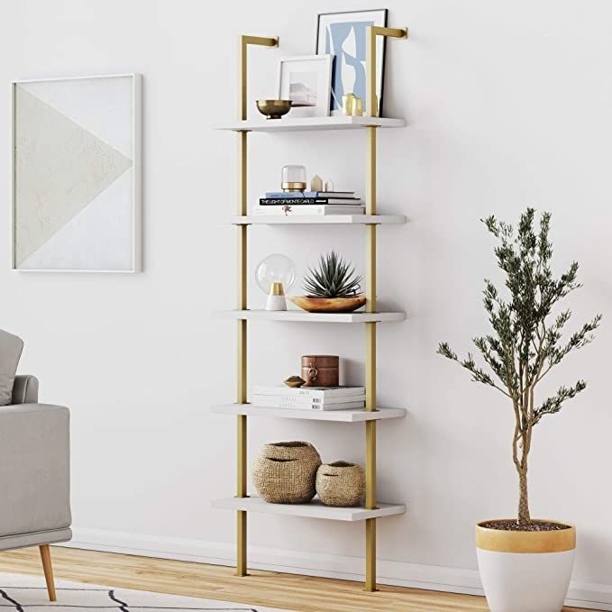The bookshelf in a chic combination of gold and white.