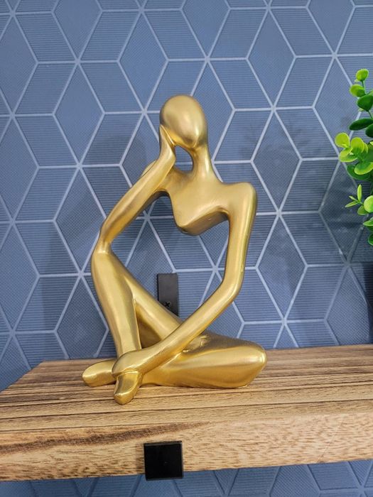 A reviewer's gold thinker statue, adding a touch of elegance to the room.