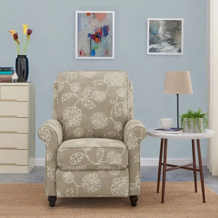 A charming floral-patterned armchair in a snug living room arrangement, accompanied by a side table with a lamp, plant, and cup. Perfect for home decor inspiration