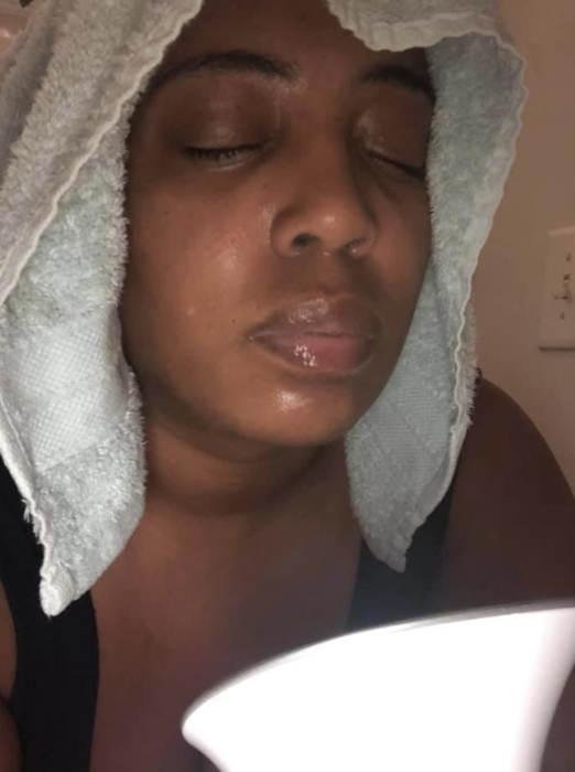 A reviewer using the steamer on their face.