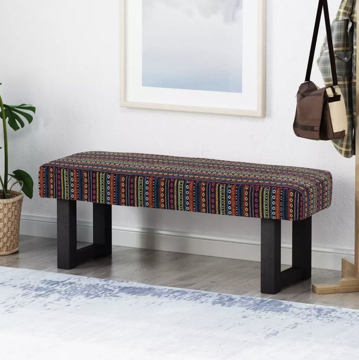 The bench placed in the entryway beside a coat rack.