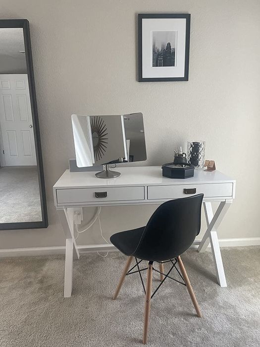 Reviewer photo featuring a black plastic chair with wooden legs positioned at their desk.