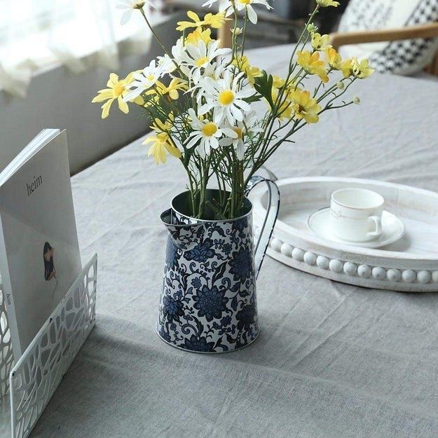 The blue rustic pitcher holding a beautiful bouquet of flowers.