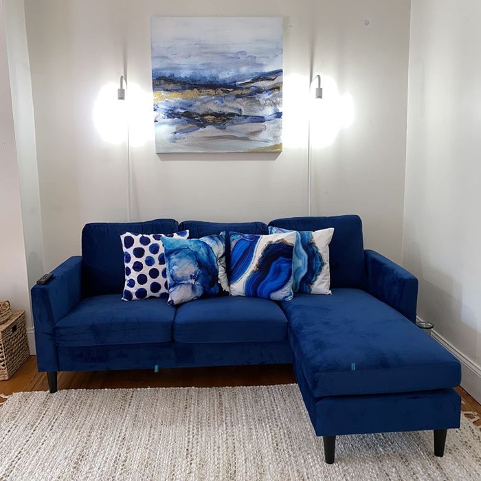 A photo submitted by a reviewer showing a blue velvet sofa in a cozy living room setting