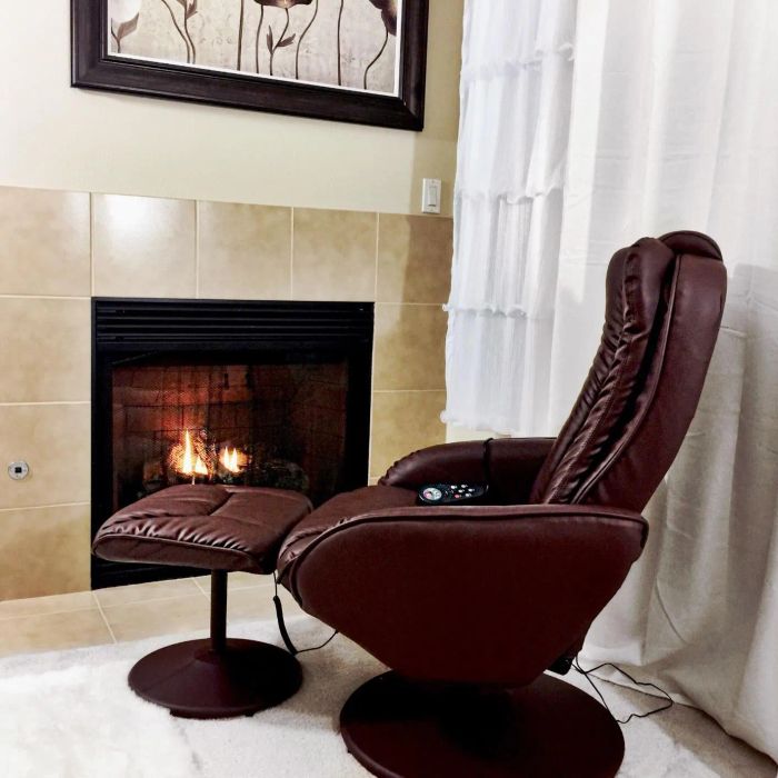 a side view of the reviewer's brown recliner with an ottoman placed near a fireplace