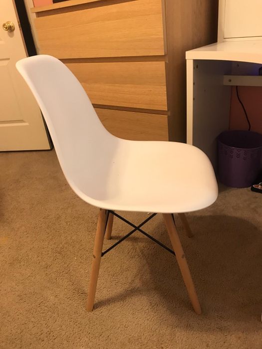 Reviewer photo showing a white plastic chair with wooden legs.