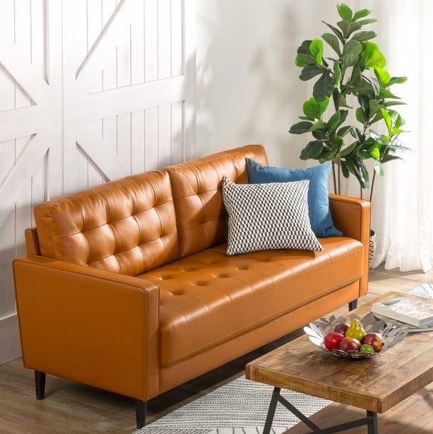 A brown sofa with throw pillows, complemented by a wooden coffee table in front of it.