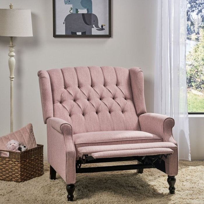 The same tufted armchair with its footrest fully extended