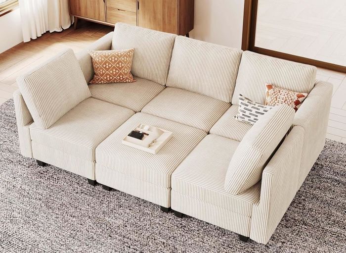 A modular sofa with hidden storage compartments beneath the cushions, featuring books and pillows as part of its display.