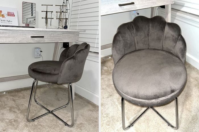 Reviewer image of a gray velvet vanity chair with a scalloped back and silver metal legs, placed on a brown carpet.