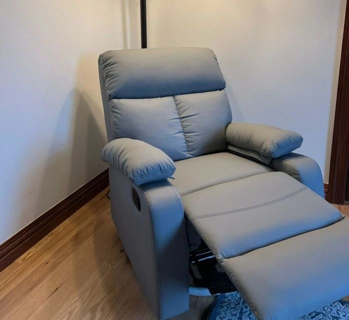A cozy recliner chair placed beneath a dual-light standing lamp