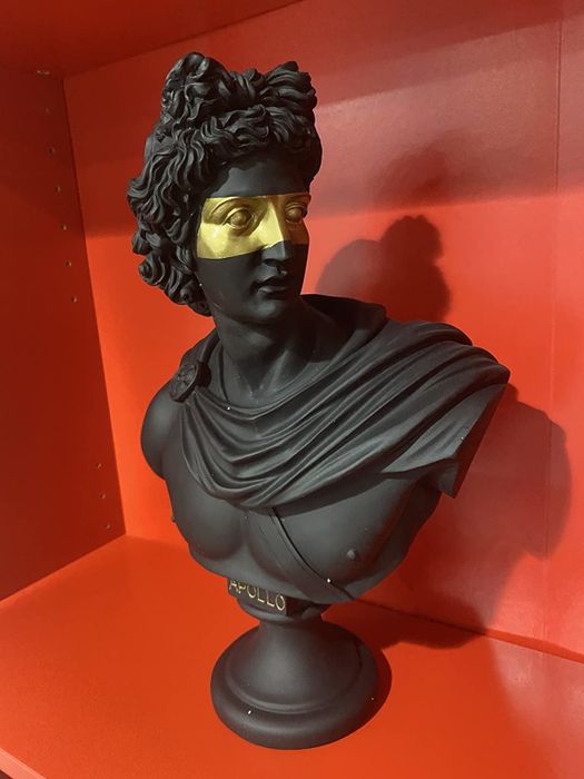 The reviewer's black and gold bust is shown on a red shelf.