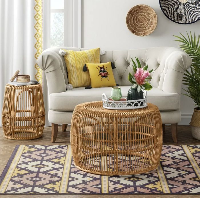 The coffee table, with a serving tray on its top surface, is placed in front of the sofa, accompanied by a matching accent table positioned beside it.