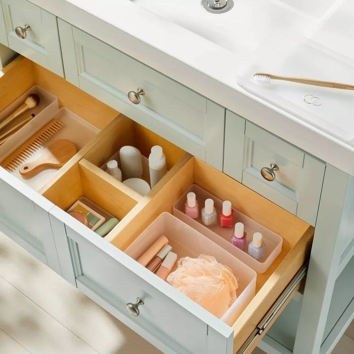 A collection of plastic drawer organizers filled with assorted items.