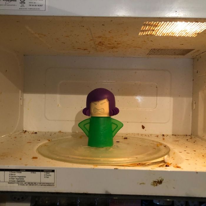 A reviewer's 'before' photo showing a messy microwave with the cleaner placed inside, ready to work its magic.