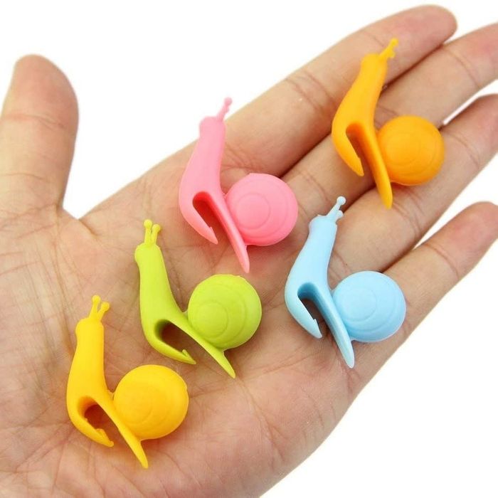 A hand holding five snails to showcase their shape.