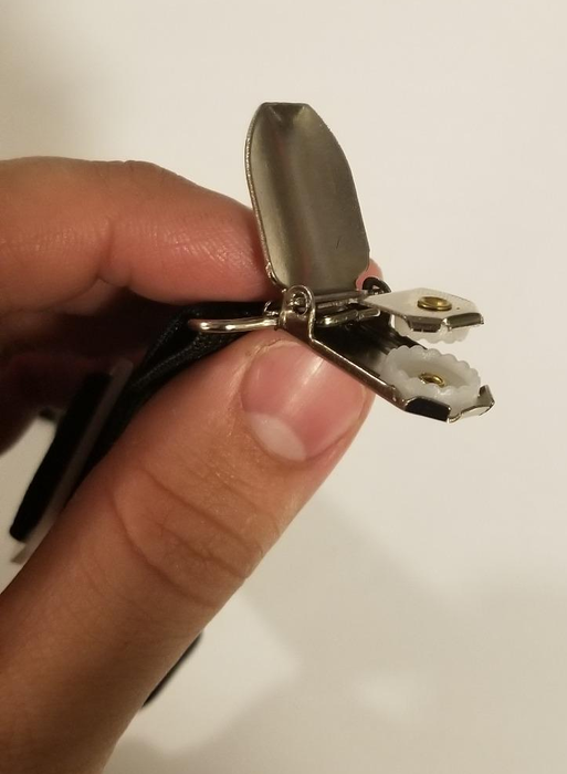 A reviewer demonstrates the product by holding one of the fasteners in their hand.