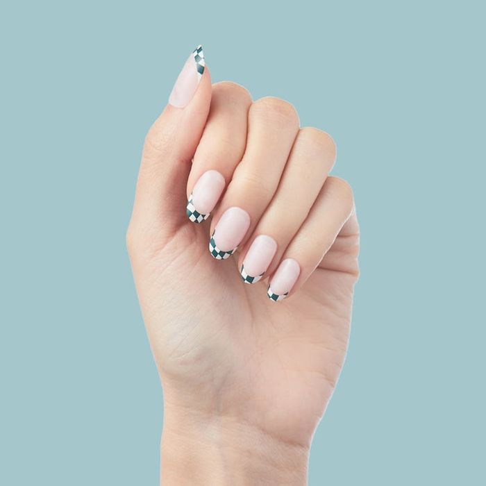 A model wearing the short, checkered press-on nails.