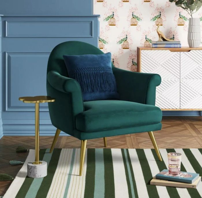 The table placed beside a teal armchair