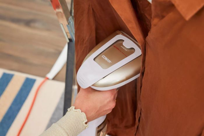 A close-up of the Conair Turbo ExtremeSteam Hand-Held Fabric Steamer in action on a shirt