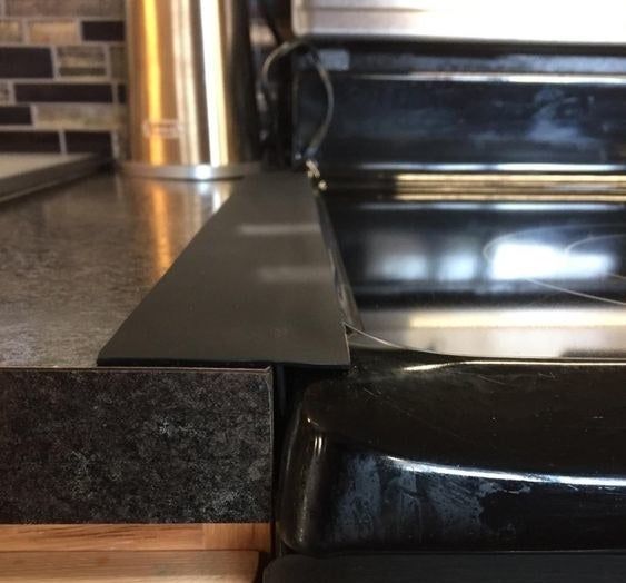 A photo from a reviewer showing the black gap cover in place next to their stove.
