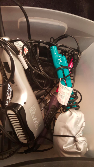 A reviewer’s photo showing hair tools in a chaotic pile before organizing.