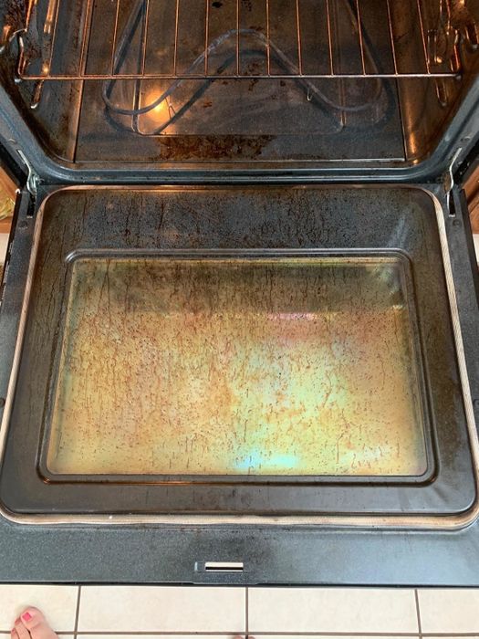 A reviewer’s photo showing a dirty oven before using the Goo Gone cleaner.