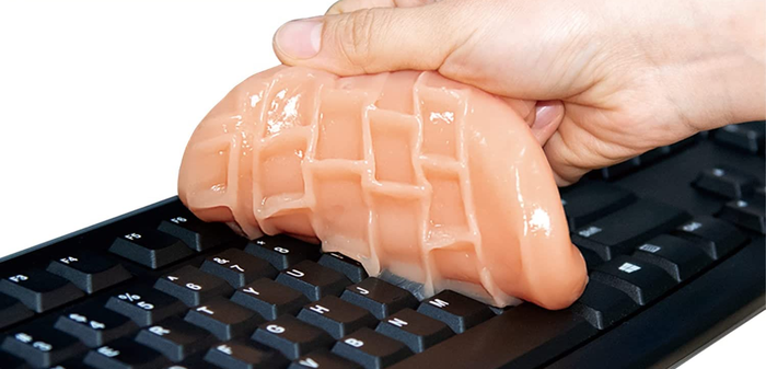 A model demonstrating how to use the putty to clean a computer keyboard.