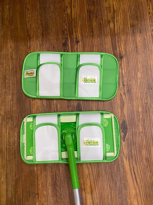 A reviewer demonstrates how the reusable pad attaches to the Swiffer mop.