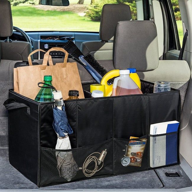 A black trunk organizer packed with bags, bottles, and car essentials.