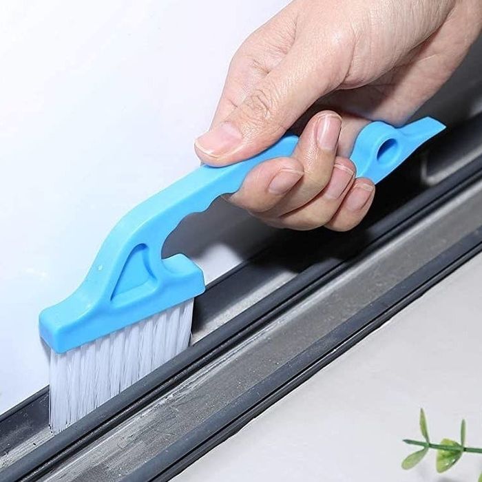 A model demonstrating the use of the blue cleaning brush on a window