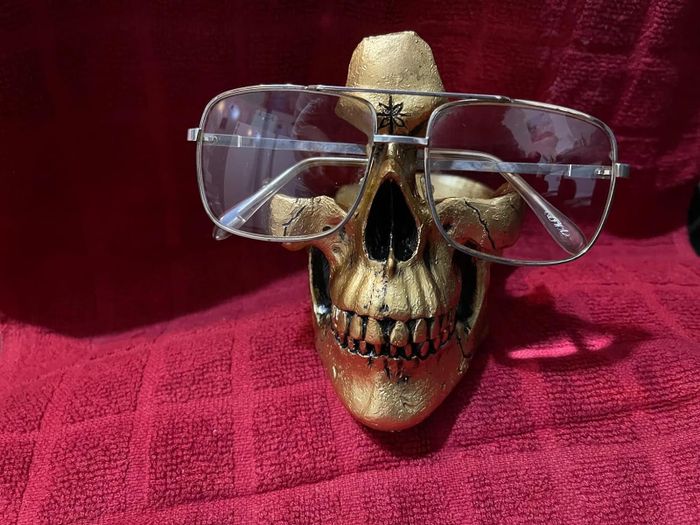 A golden skull with a pair of glasses resting on it